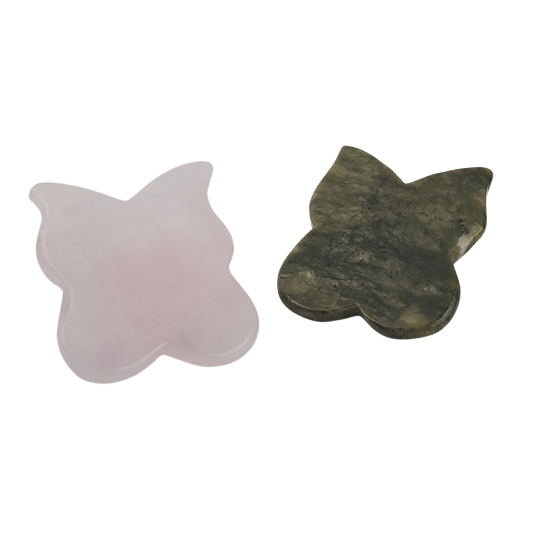 Butterfly gua sha tools, one pale pink stone and one mottled dark green stone side by side