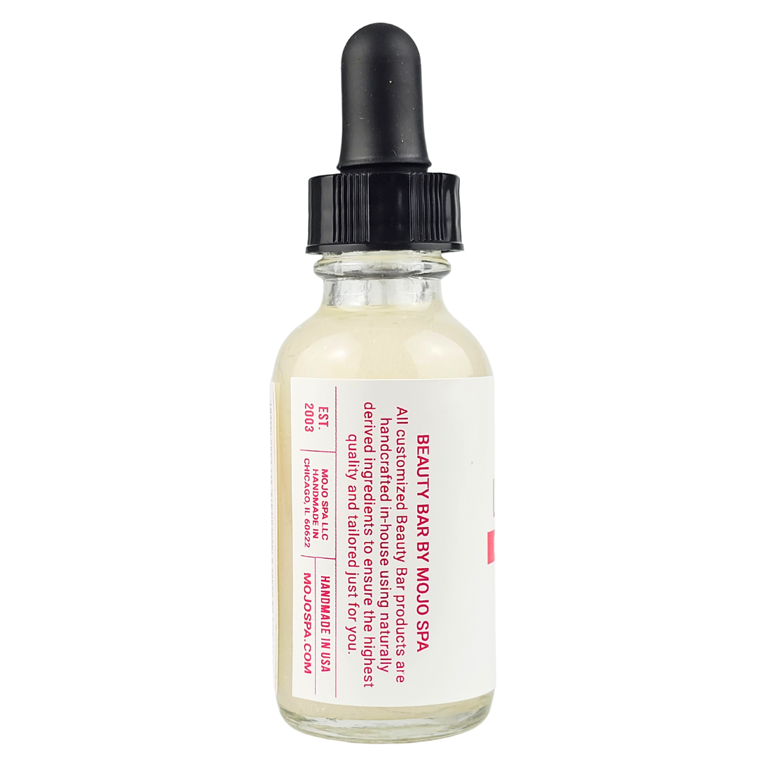 The side of the dropper bottle, its label describing Beauty Bar products as handcrafted in-house