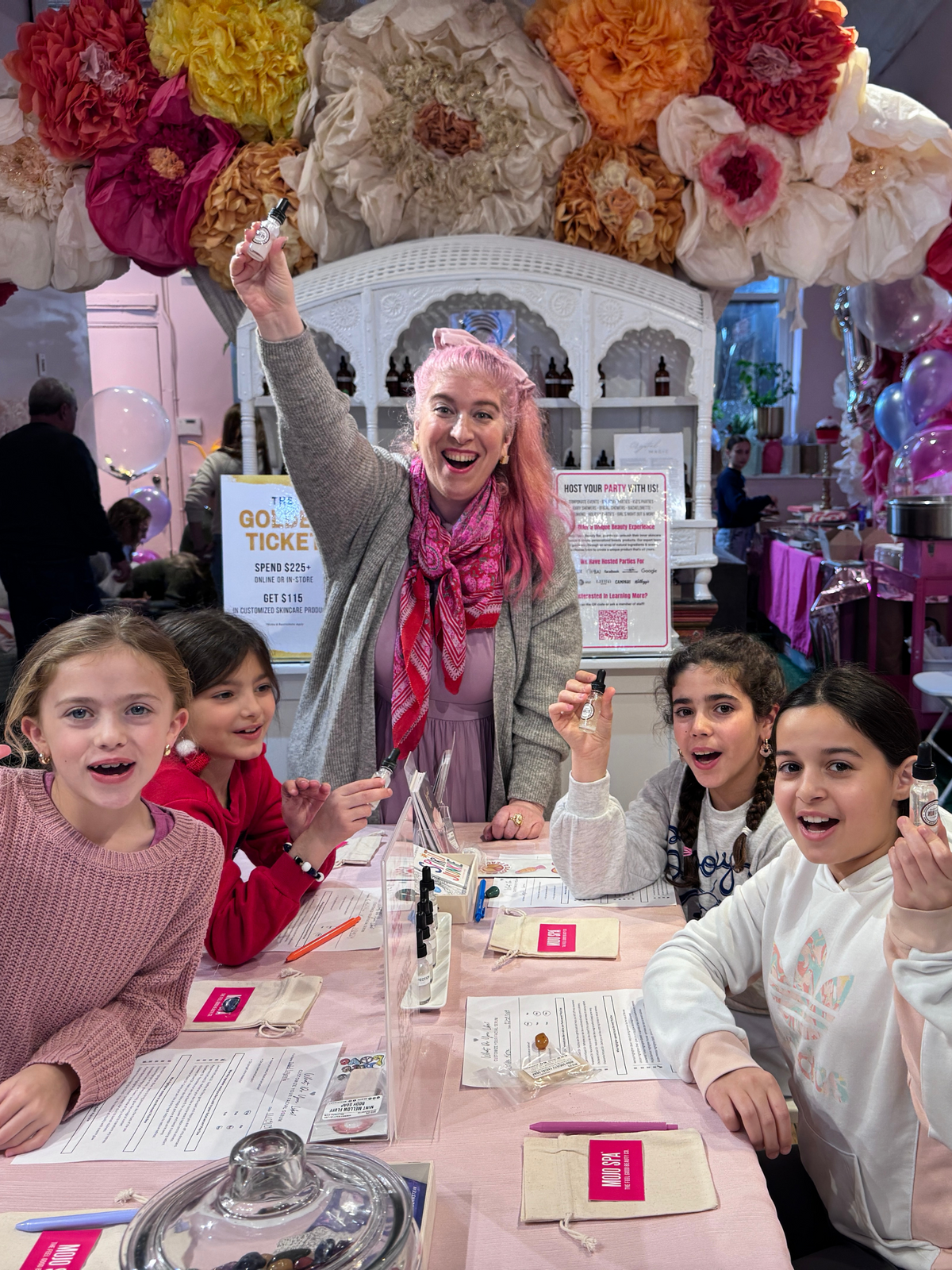 Amanda celebrating with party guests holding up their finished serums