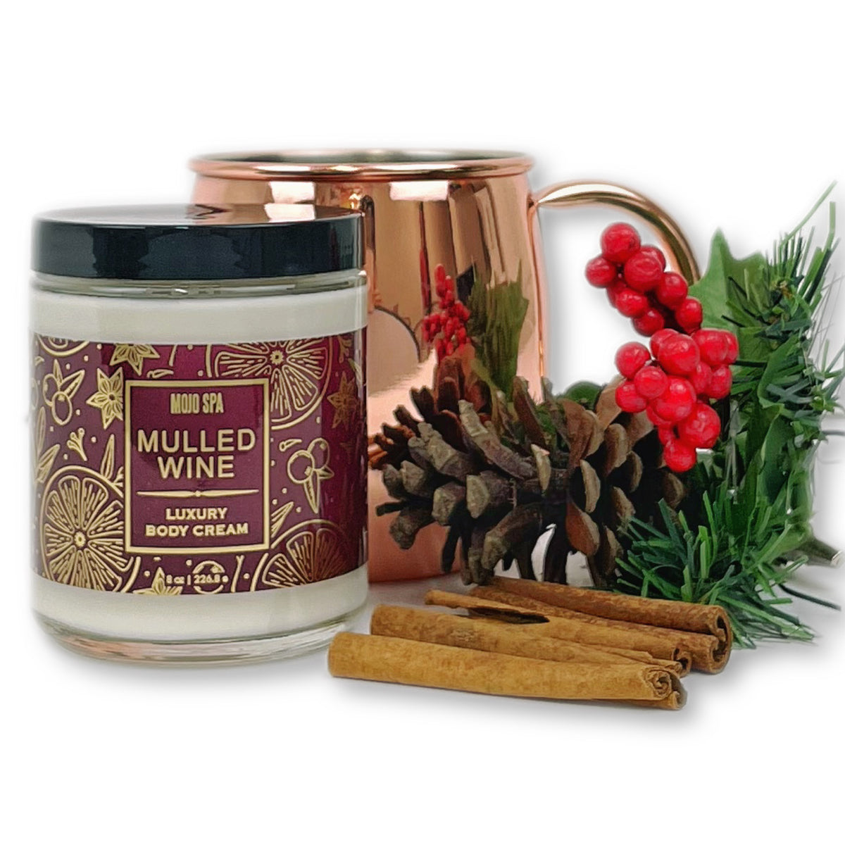 The jar beside a copper mug, a pine cone, cinnamon sticks and red berries on evergreen sprigs
