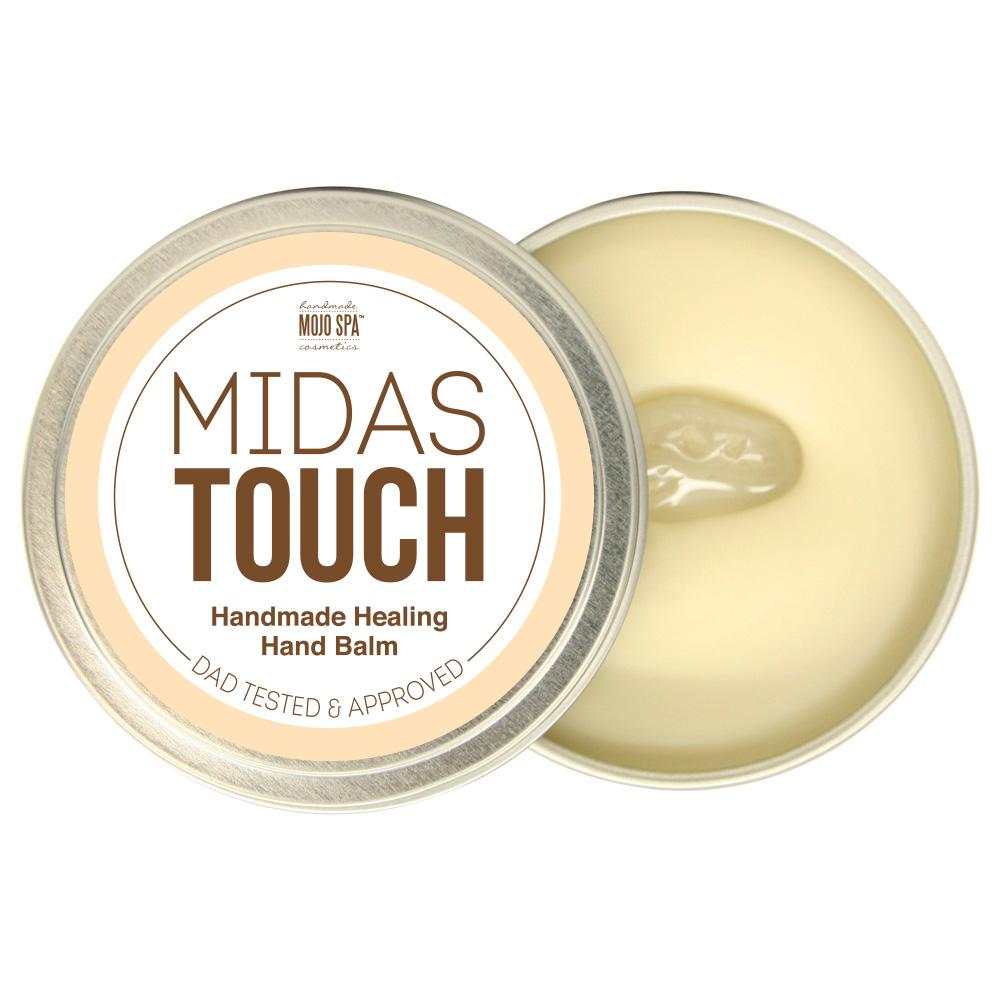 Midas Touch hand balm in an open round silver tin beside its lid, showing the smooth pale balm