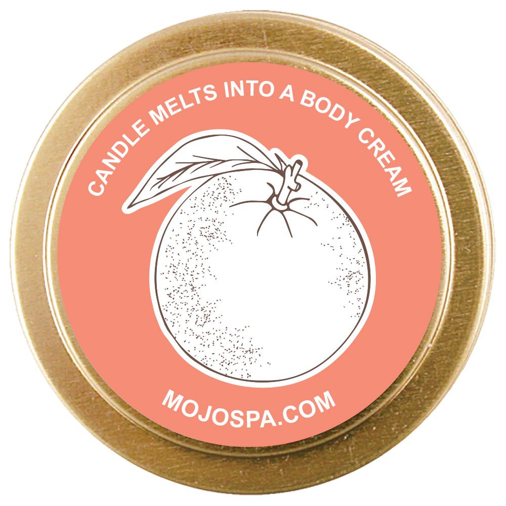 The coral lid of the gold tin from above, showing a drawing of a fruit and the words candle melts into a body cream