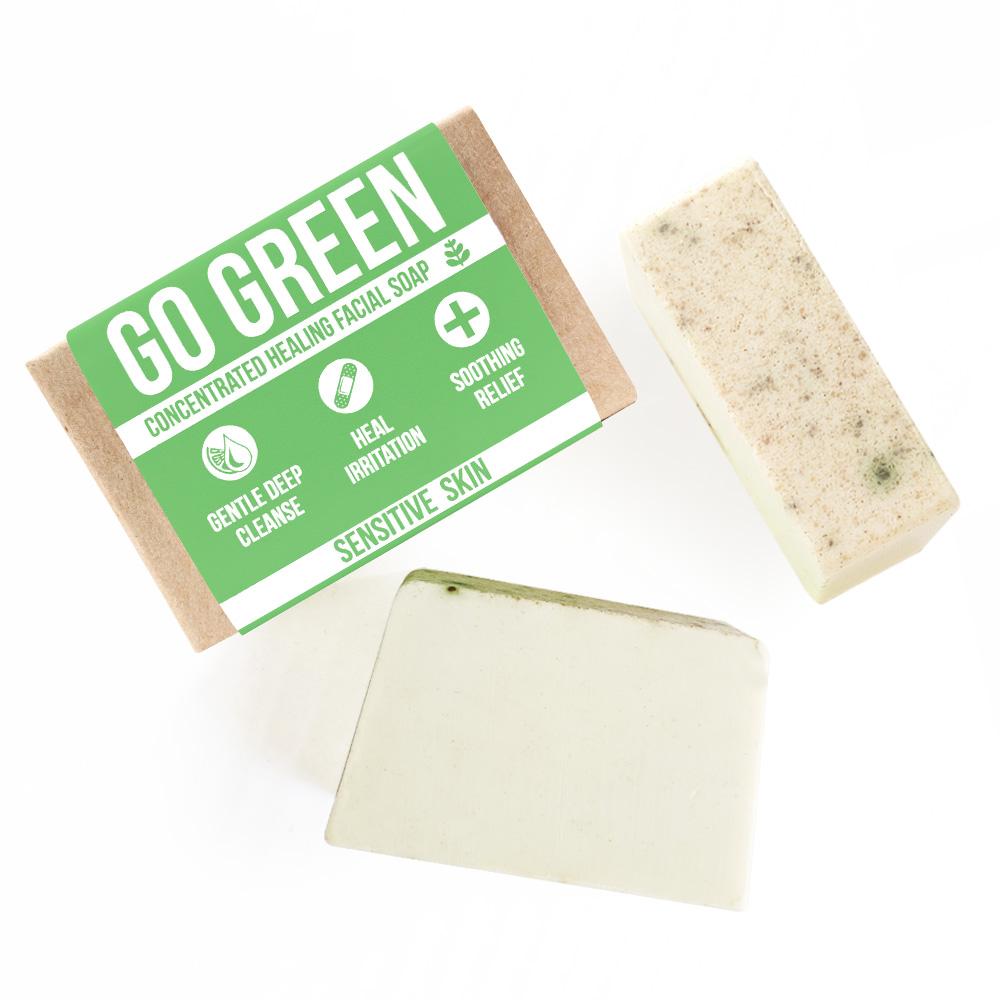 The wrapped bar beside an unwrapped bar and a cut piece, pale green with fine herb flecks