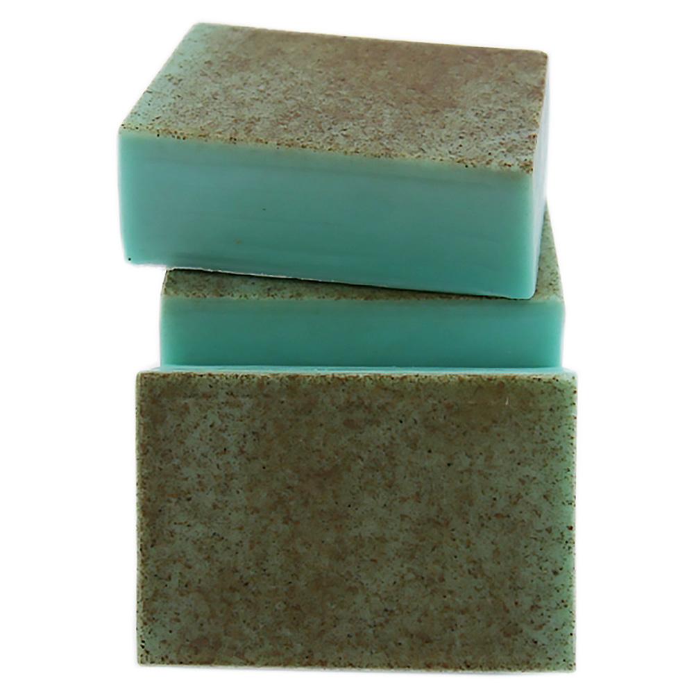 Another view of the soap, showing a stack of green bars with a rough, brown-flecked surface