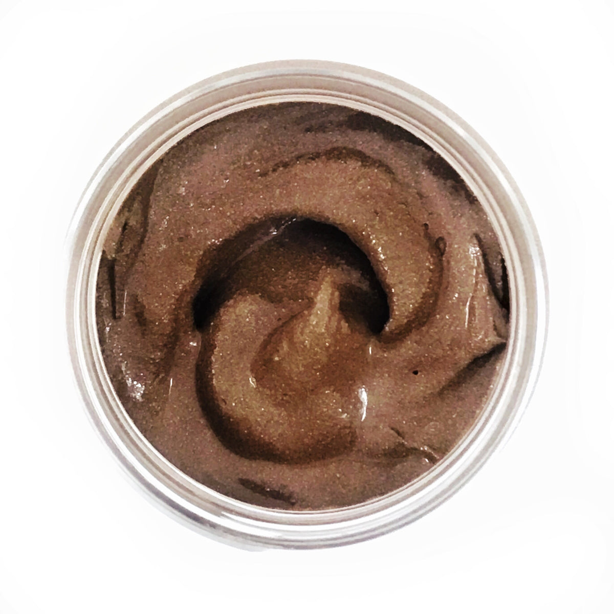 The facial mask seen from above, a smooth brown swirl in the open jar