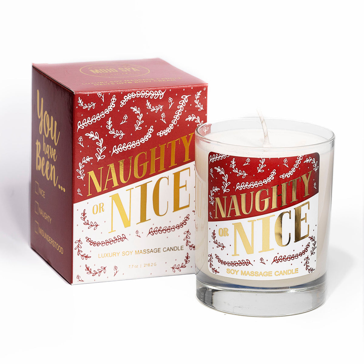 Naughty or Nice soy massage candle in a clear glass beside its red, white and gold box