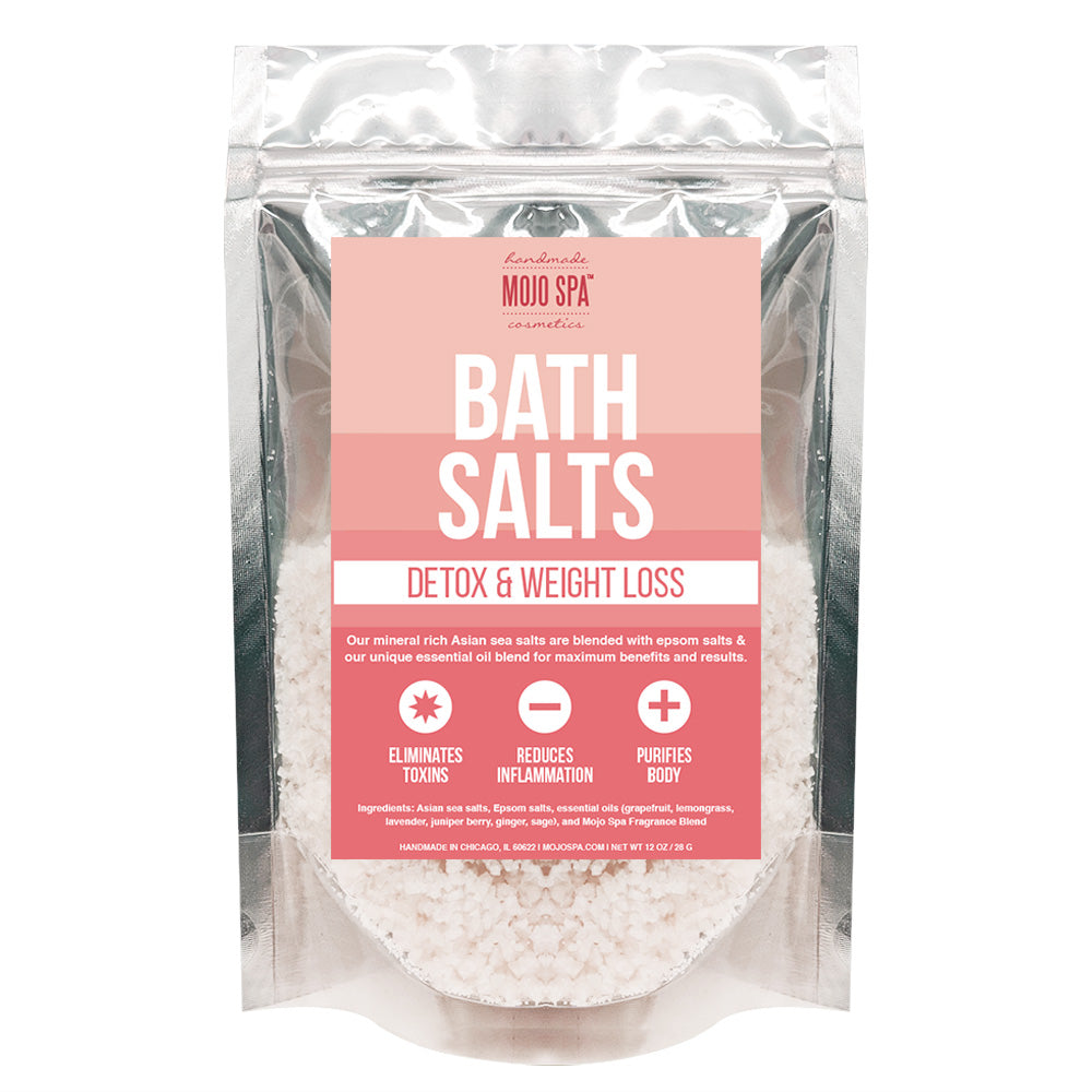 Mojo Spa bath salts in a clear and silver zip pouch with a pink label, white salts showing through