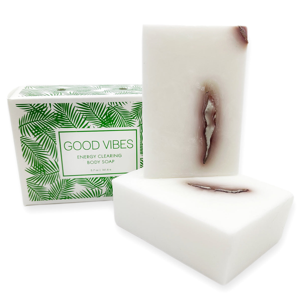 Two white soap bars with a dark reddish streak beside the printed box