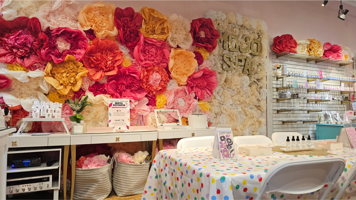 The Beauty Bar table in front of the Mojo Spa flower wall