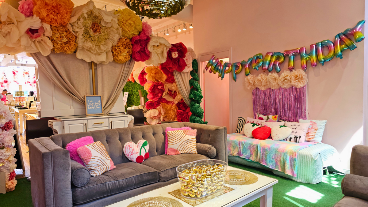 The party lounge decorated for a birthday, with a Happy Birthday balloon banner
