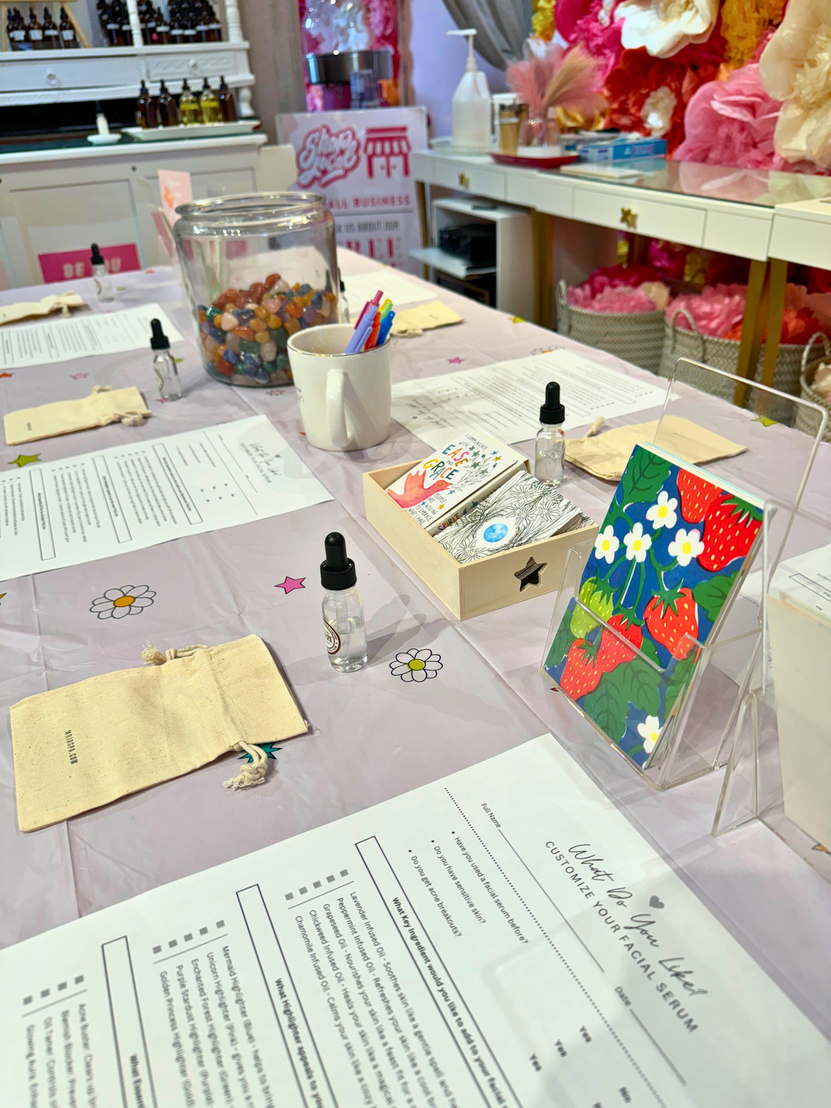 The Beauty Bar table set with worksheets, gift pouches and a jar of crystals