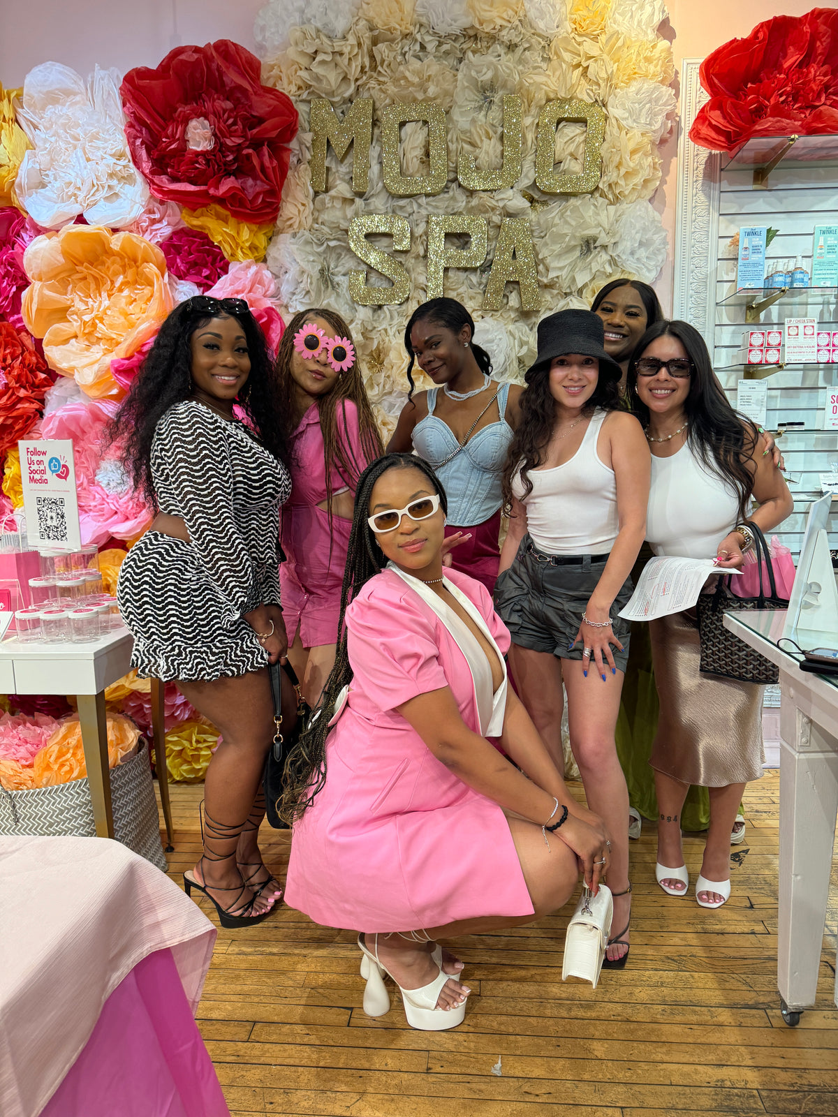 A group of friends posing in front of the Mojo Spa sign