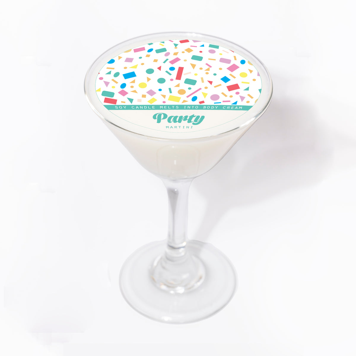 Party Martini soy massage candle in a martini glass, seen from above, with a white lid of colourful confetti and a teal band