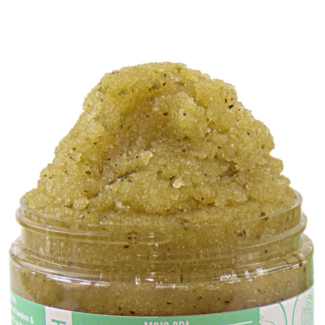 Close-up of the scrub heaped above the open jar, showing sugar crystals and green flecks